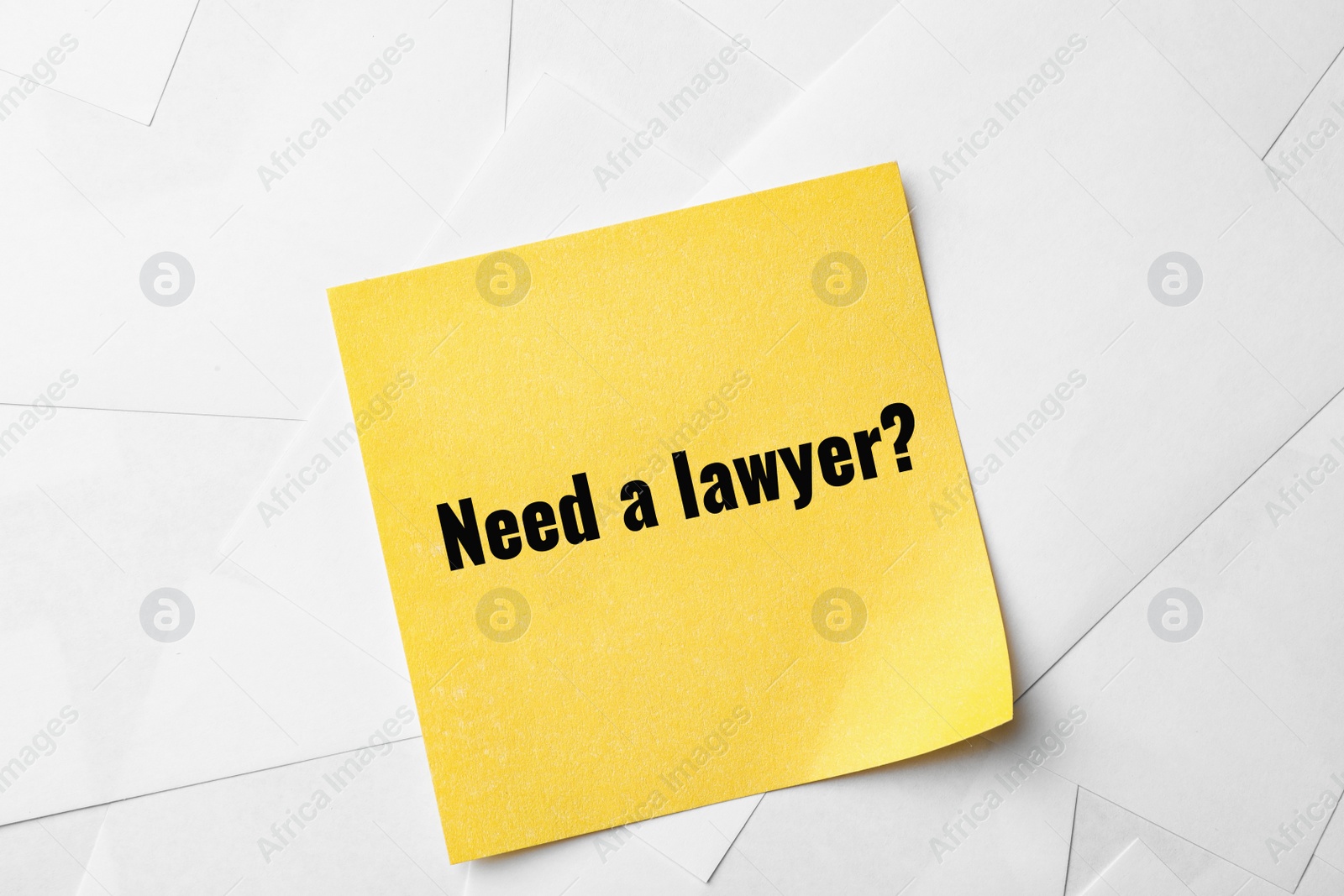 Image of Note with text NEED A LAWYER? on paper sheets, top view