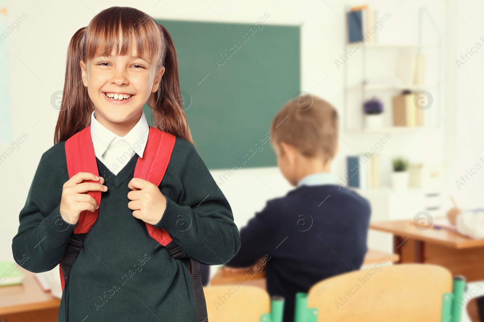 Image of Happy girl with backpack in school classroom