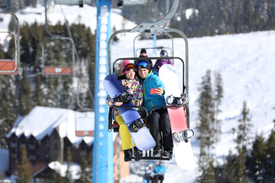 Photo of Couple taking selfie while lifting at mountain ski resort. Winter vacation