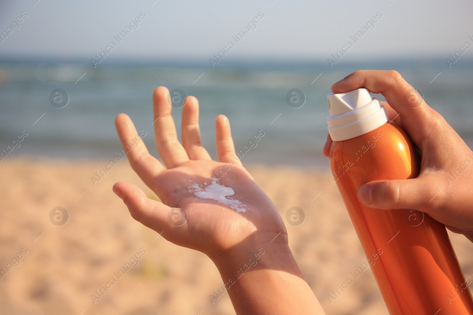 Photo of Child applying sunscreen near sea, closeup. Sun protection care