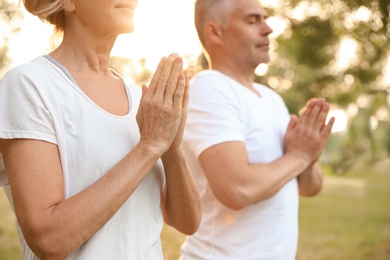Photo of Couple practicing yoga in park at morning, closeup