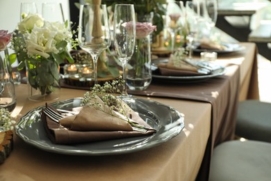 Photo of Festive table setting with beautiful tableware and floral decor in restaurant