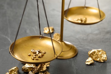 Vintage scales with gold nuggets on black marble table