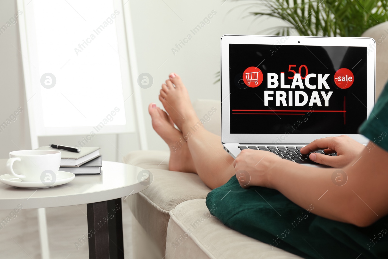 Photo of Woman using laptop with Black Friday announcement on screen, closeup