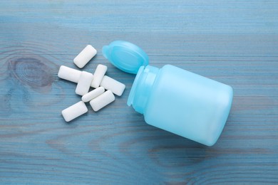 Jar with chewing gums on light blue wooden table, flat lay