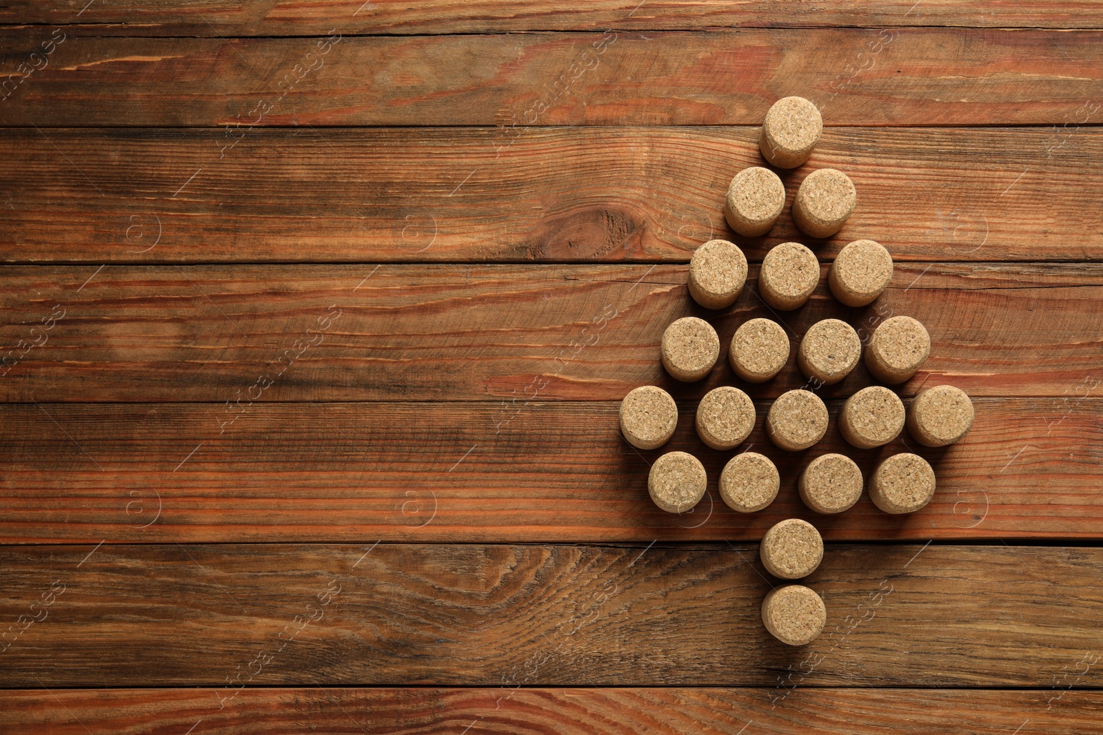 Photo of Christmas tree made of wine corks on wooden table, top view. Space for text