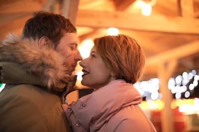 Cute couple in warm clothes at winter fair