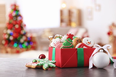 Image of Gift box with Christmas cookies and balls on table in decorated room 