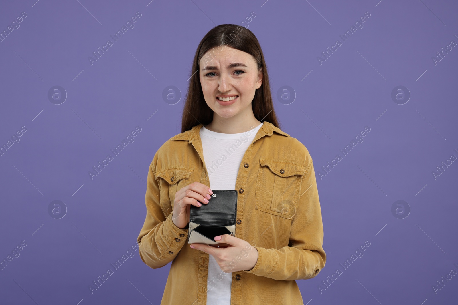 Photo of Woman showing empty wallet on purple background