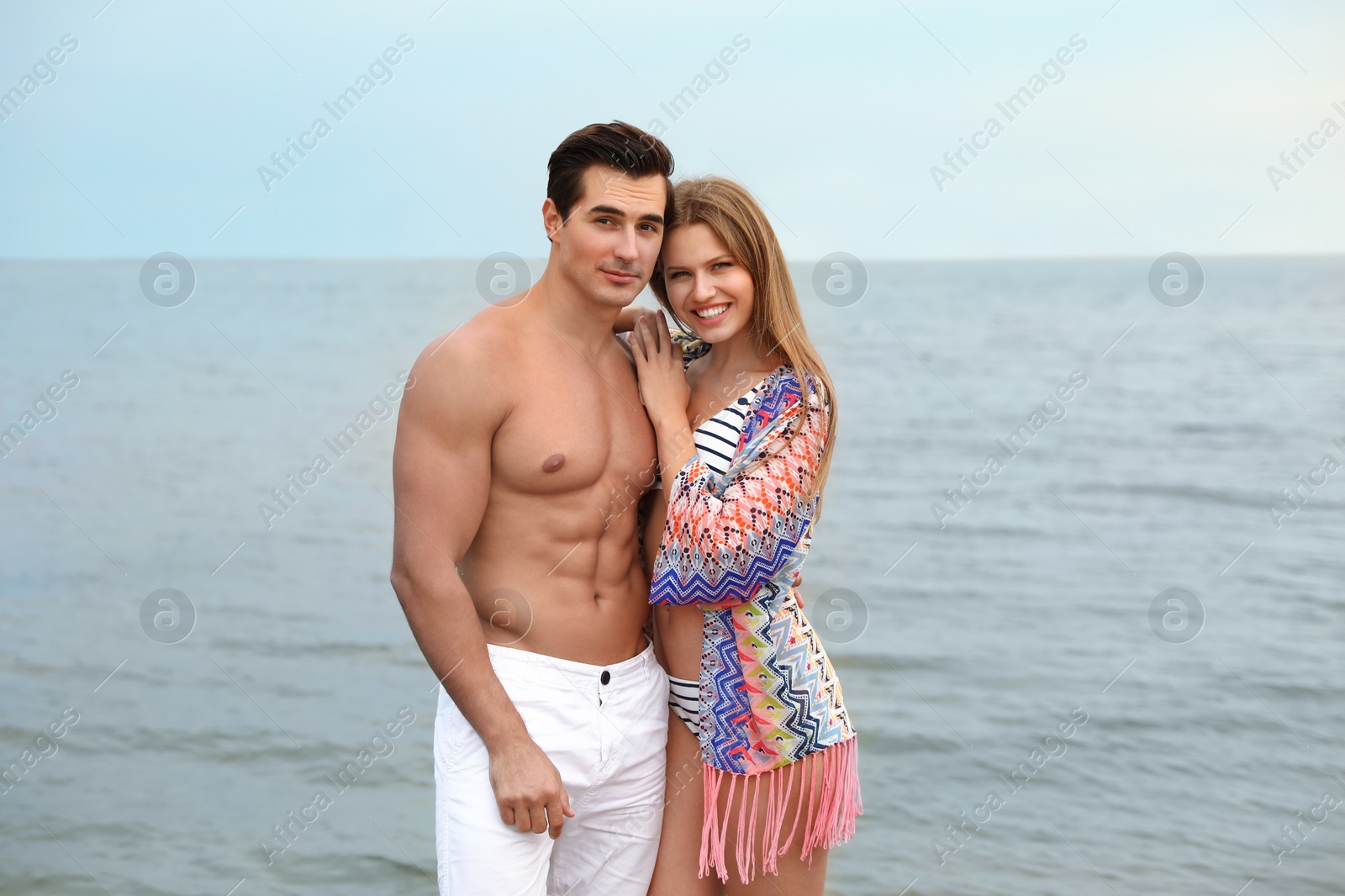 Photo of Happy young couple spending time together on sea beach