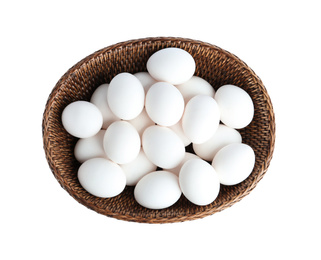 Photo of Chicken eggs in wicker bowl isolated on white, top view