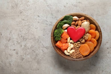 Bowl with heart-healthy products on grey background, top view. Space for text