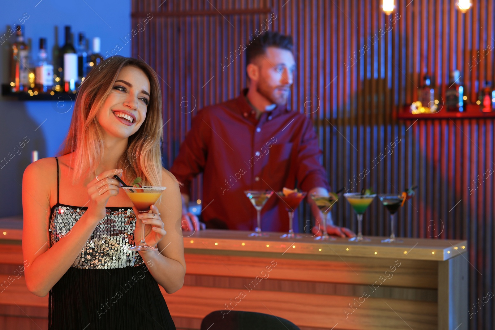 Photo of Beautiful young woman with glass of martini cocktail in bar