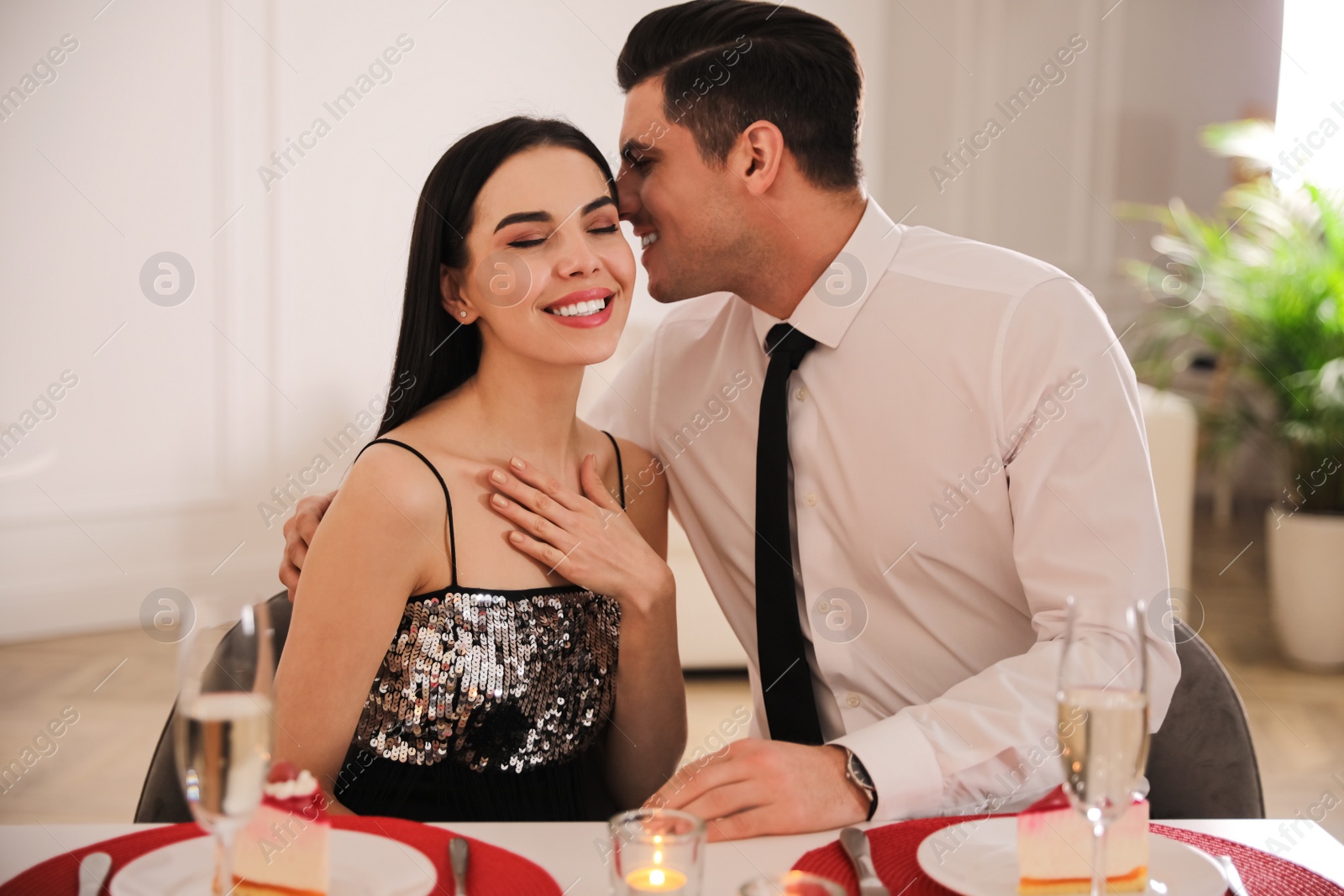 Photo of Happy couple having romantic dinner on Valentine's day indoors