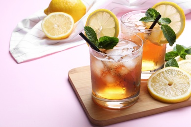 Photo of Delicious iced tea with lemon and mint on pink background, closeup