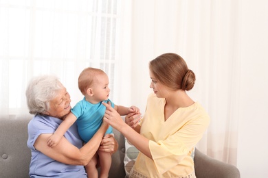 Happy young woman with her child and grandmother at home