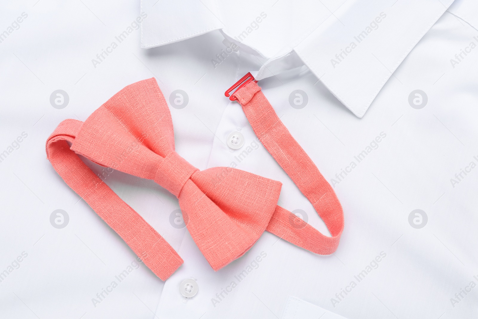 Photo of Stylish bow tie on white shirt, top view