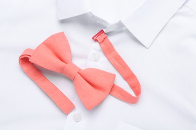 Stylish bow tie on white shirt, top view