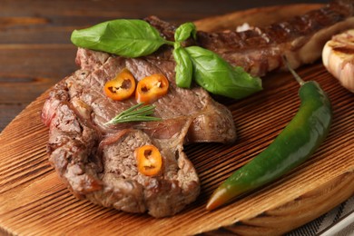 Photo of Delicious fried beef meat with garlic and chili pepper on table, closeup
