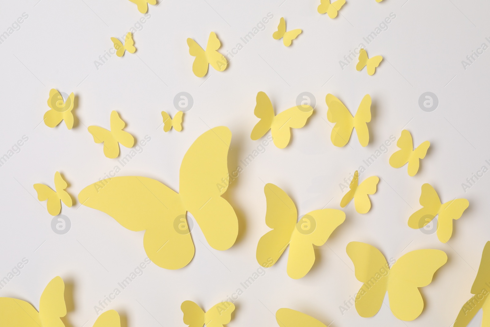 Photo of Yellow paper butterflies on white background, top view