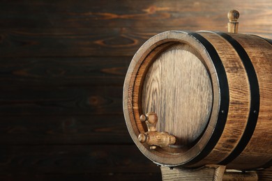 Photo of One wooden barrel with tap near wall, closeup. Space for text