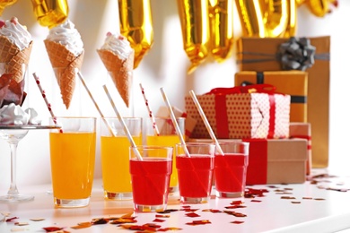 Treats and gifts on table in room decorated for birthday party