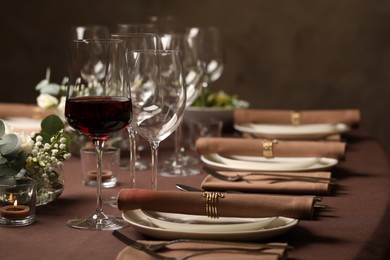 Photo of Glass of delicious wine and elegant table setting in restaurant