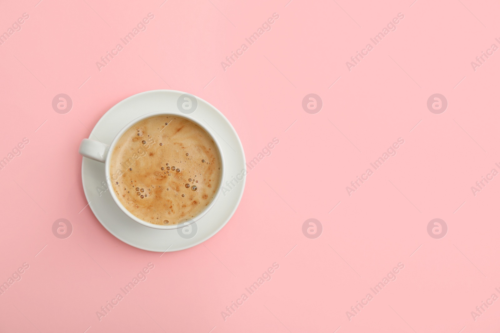 Photo of Cup of coffee on pink background, top view. Space for text