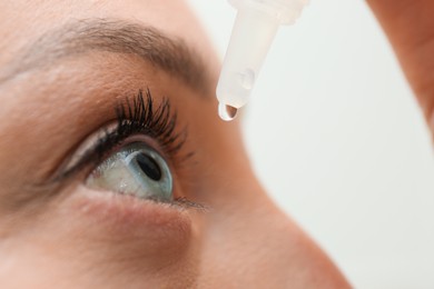 Photo of Young woman using eye drops, closeup view