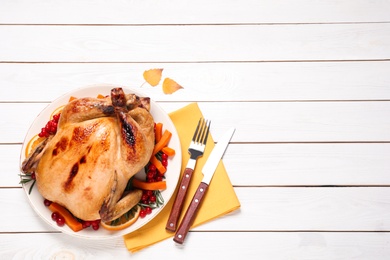 Delicious cooked turkey served on white wooden table, flat lay with space for text. Thanksgiving Day celebration