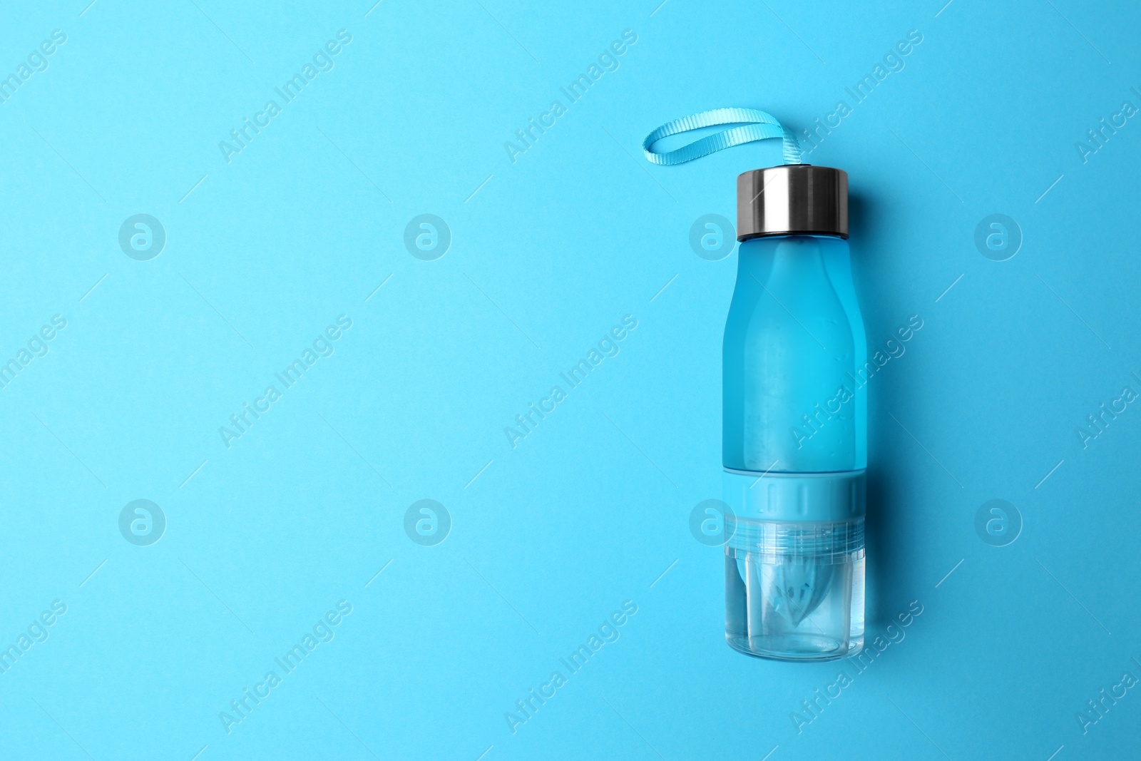 Photo of Sport bottle with space for text on color background, top view