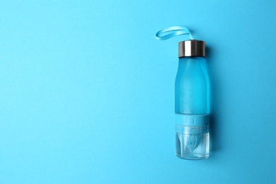 Photo of Sport bottle with space for text on color background, top view