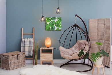 Photo of Elegant living room interior with hanging armchair and fuzzy rug