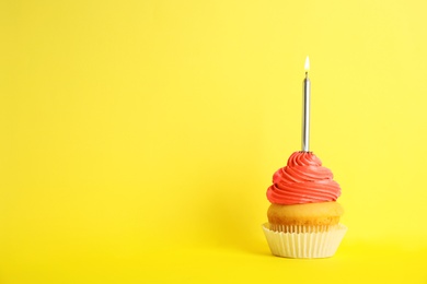 Photo of Birthday cupcake with candle on yellow background, space for text