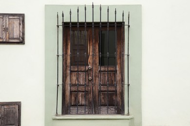Photo of Building with wooden window and steel grilles