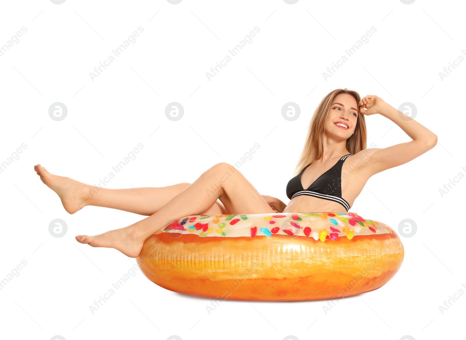 Photo of Beautiful young woman in stylish bikini with doughnut inflatable ring on white background