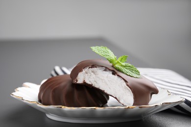 Photo of Delicious chocolate covered zephyrs with mint on black table