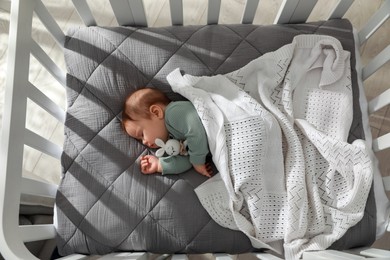 Cute little baby sleeping in crib, top view. Bedtime