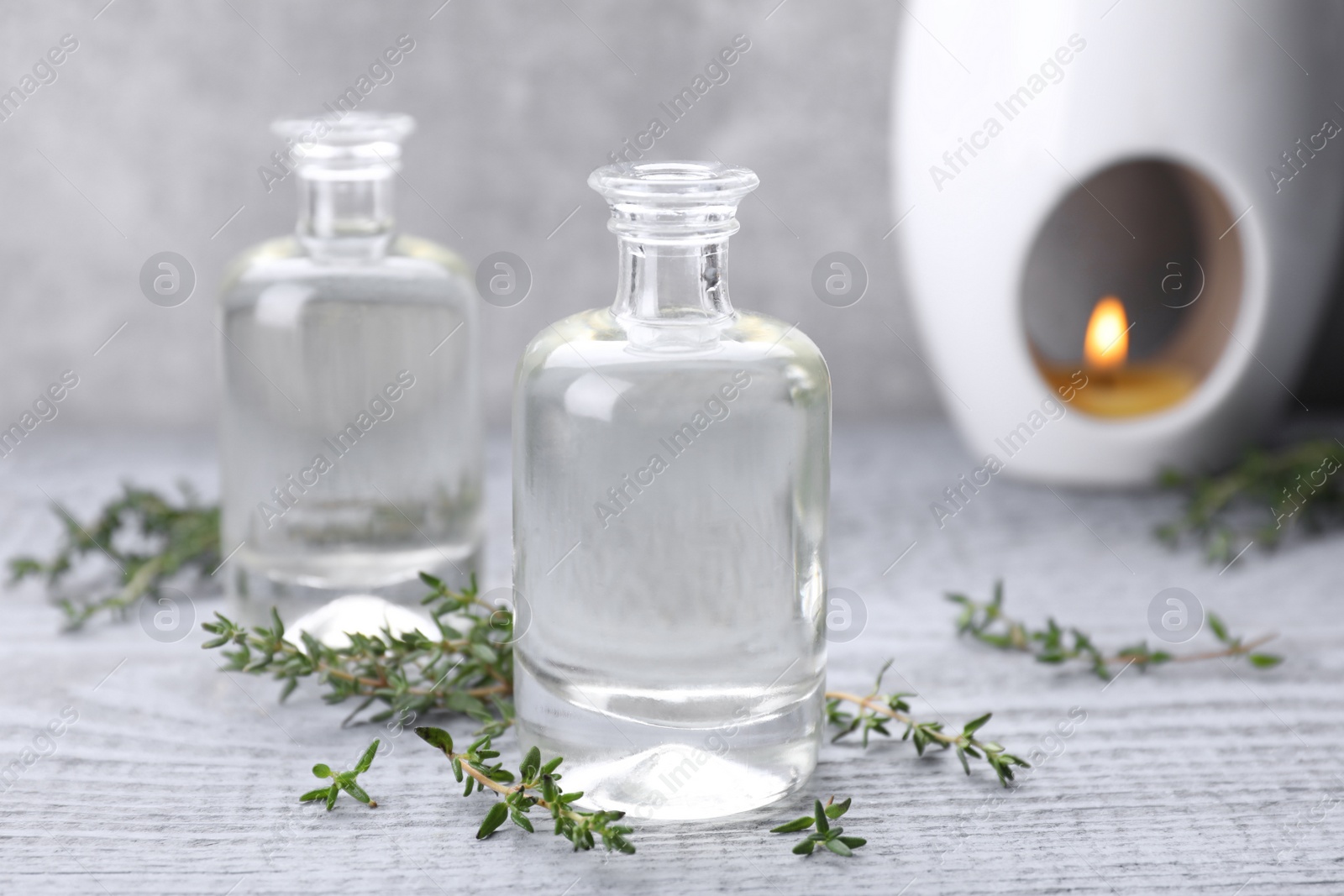Photo of Thyme essential oil on light blue wooden table