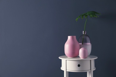 Photo of Living room interior with vases and table near dark wall. Space for text