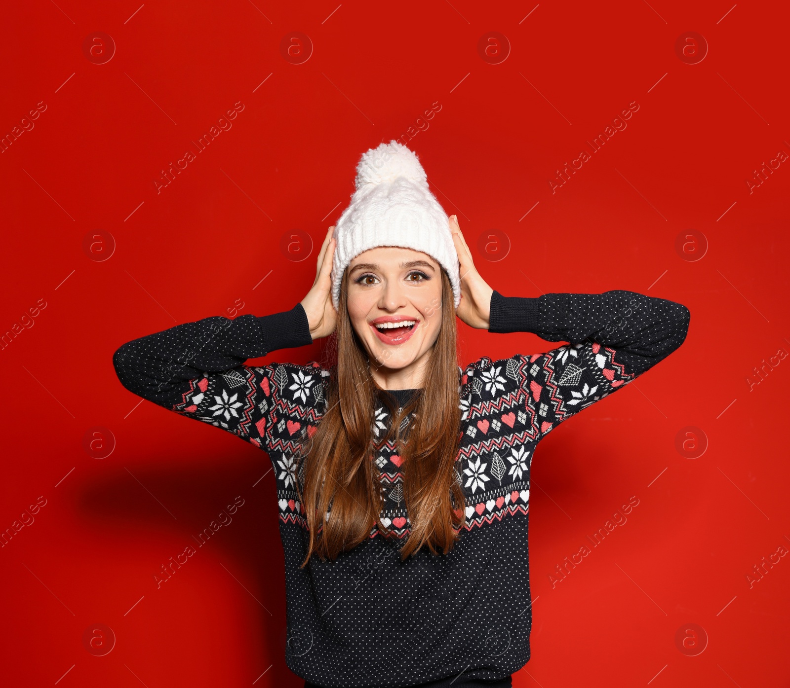 Photo of Young woman wearing Christmas sweater on red background