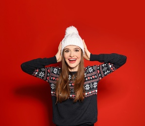 Photo of Young woman wearing Christmas sweater on red background