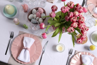 Festive table setting with beautiful flowers, flat lay. Easter celebration