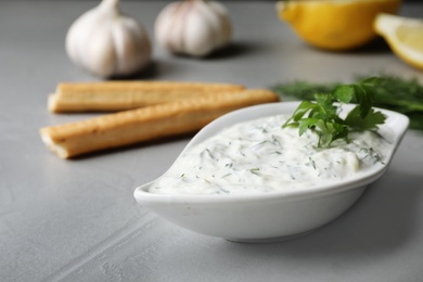 Photo of Gravy boat with cucumber sauce on grey table