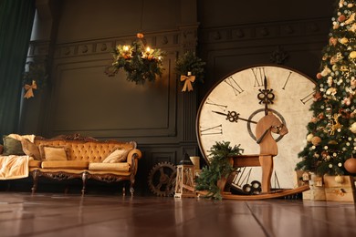 Photo of Stylish room interior with Christmas tree, big vintage clock and festive decor