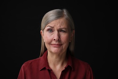 Photo of Personality concept. Portrait of woman winking on black background