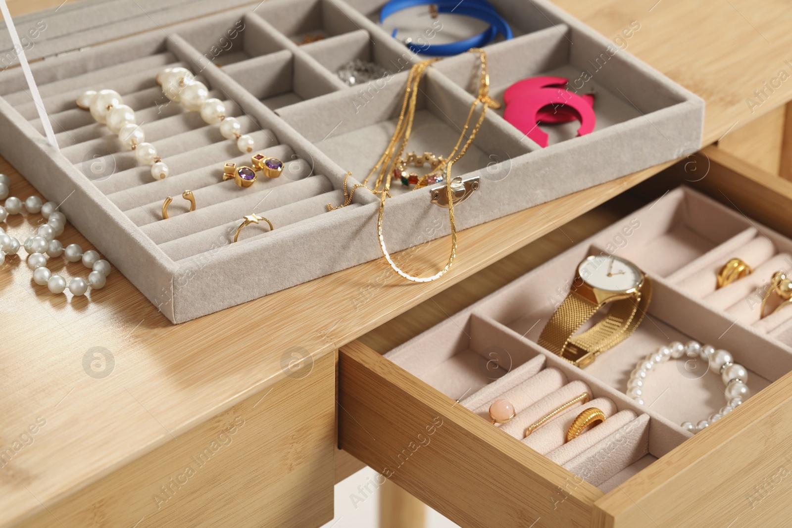 Photo of Jewelry boxes with many different accessories on wooden table, closeup