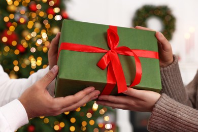 Photo of Woman receiving Christmas gift from her boyfriend at home, closeup