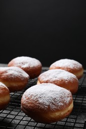 Delicious sweet buns on table against black background, space for text