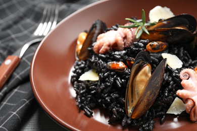 Delicious black risotto with seafood in plate, closeup